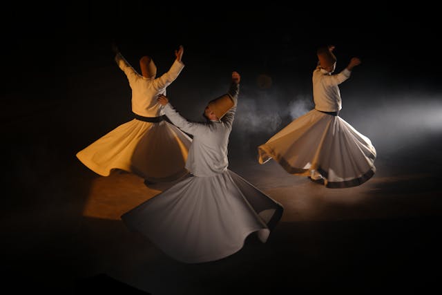 Three dervishes perform Sufi whirling, creating a mystical and spiritual ambiance.